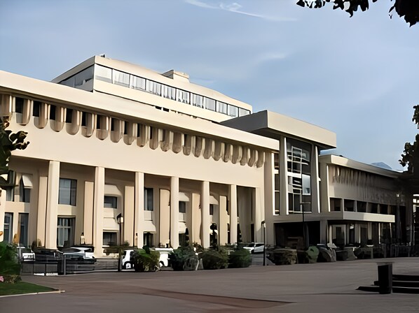 A modern building with a flat roof, large windows, and a central entrance.