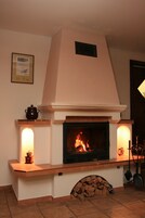 A fireplace with a mantel, a framed certificate on the wall, and a chimney.