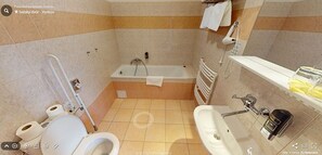 A bathroom with a bathtub, toilet, sink, and a shower area. - Hotel Selský Dvur (Vyskov)