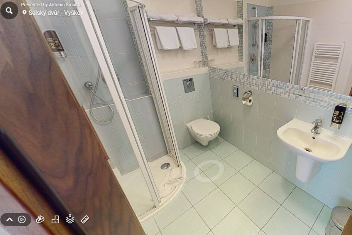 A bathroom with a shower, toilet, and sink.