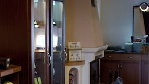 Una habitación con una estantería para vinos, un mueble con puertas de cristal, una cesta de mimbre y suelo de baldosas.
