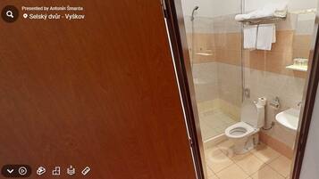 Un bagno moderno con box doccia in vetro, un water e un lavandino.