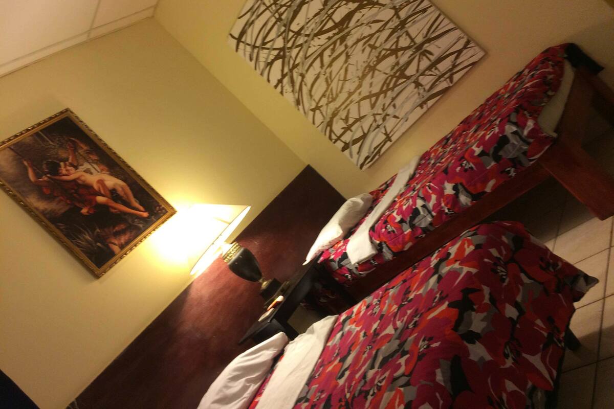 Ein Hotelzimmer mit zwei Betten, einem Bild an der Wand und einer Wanddekoration.