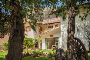 A traditional building with a tiled roof, a wooden balcony, and a sign indicating a massage service. - San Agustin Urubamba & Spa (Urubamba)