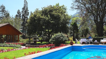 Una piscina al aire libre de temporada, sombrillas