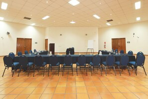 A conference room with a long table, chairs, and a whiteboard.