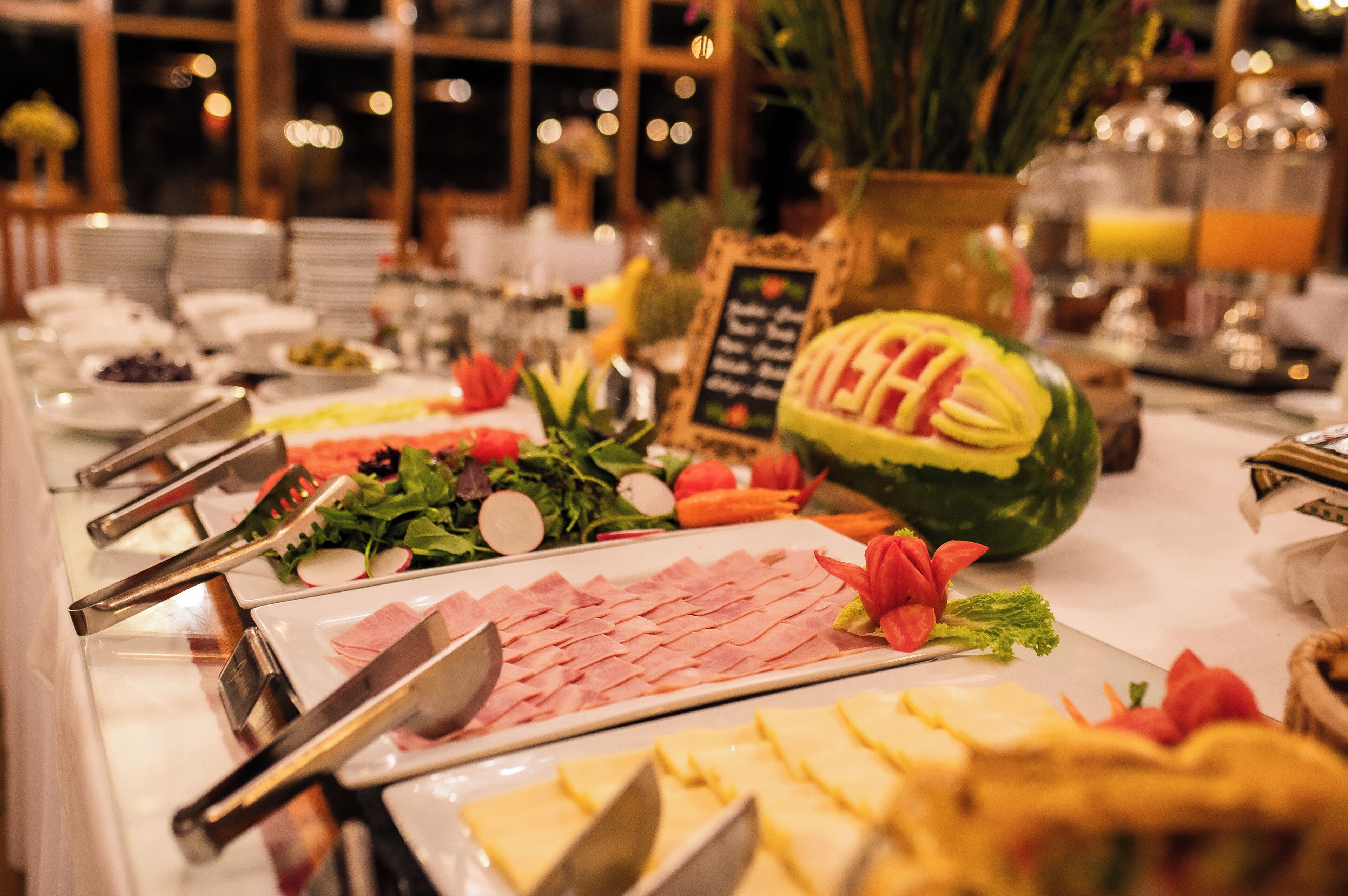 Uma mesa de buffet com diversos alimentos e utensílios.