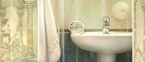 A bathroom with a marble sink, a towel, and decorative tiles.