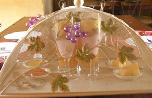 Una mesa con un vaso de bebida, un plato de comida y detalles decorativos.