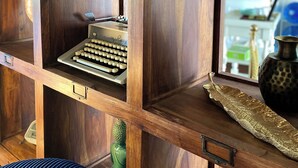 A wooden shelf unit with various items including a vintage typewriter, a radio, and decorative objects. - Logis Hôtel Médiéval, Montélimar Nord (Rochemaure)