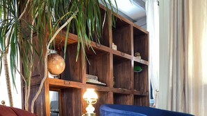 A room with a wooden bookshelf, a globe, a typewriter, and two chairs, one in pink and one in blue. - Logis Hôtel Médiéval, Montélimar Nord (Rochemaure)
