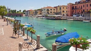 A canal with boats, a bridge, and buildings along the water. - Hotel Agli Ulivi (Valeggio sul Mincio)