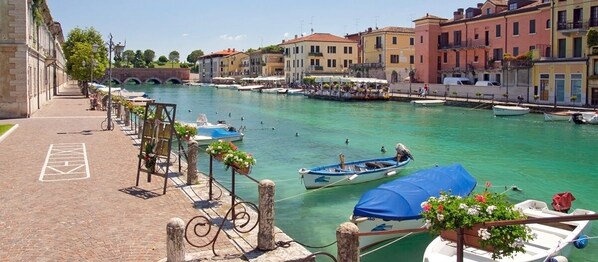Un canal con barcos, un puente y edificios a lo largo del agua.
