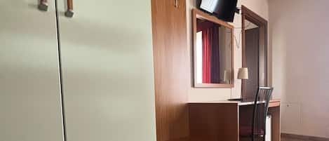 Quarto com guarda-roupa, escrivaninha e cadeira.