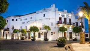 A white building with a sign reading "HOTEL" and "el Jardin del Califa Restaurante - Cafeteria". - La Casa del Califa (Vejer de la Frontera)