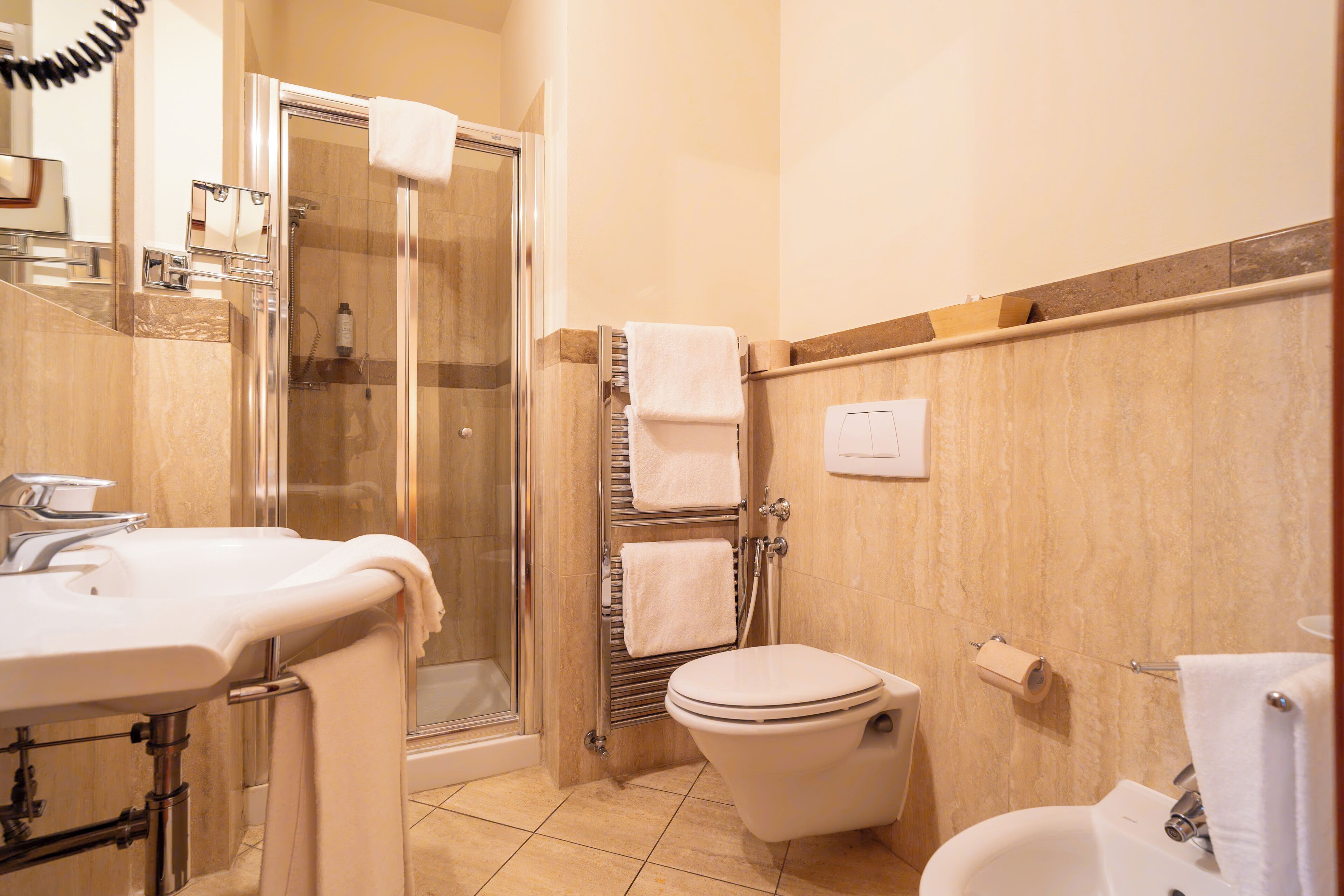 Une salle de bain avec douche, toilettes et lavabo.