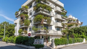A multi-story building with balconies adorned with plants. - Residence Verdeluna (Pietrasanta)