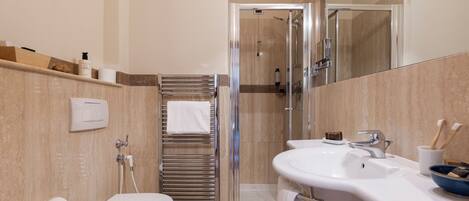 Een badkamer met toilet, wastafel, douche en spiegel.