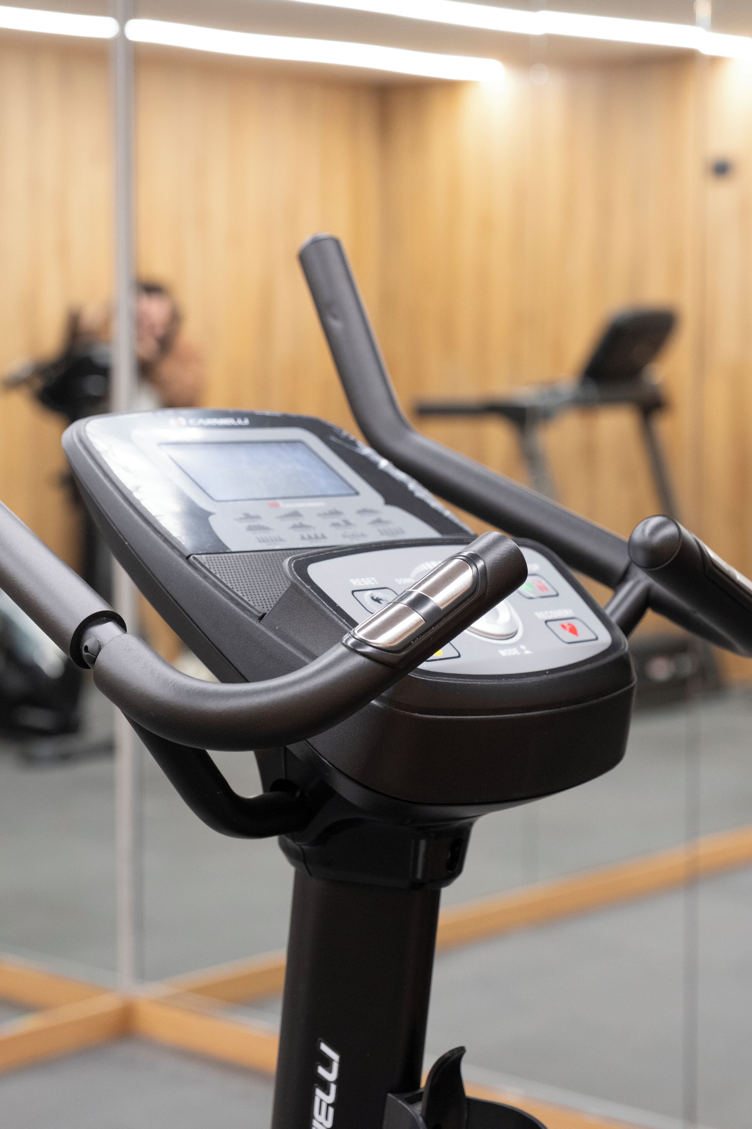 A stationary bike with a digital display, handlebars, and a control panel.