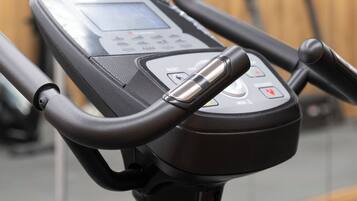 A stationary bike with a digital display, handlebars, and a control panel.