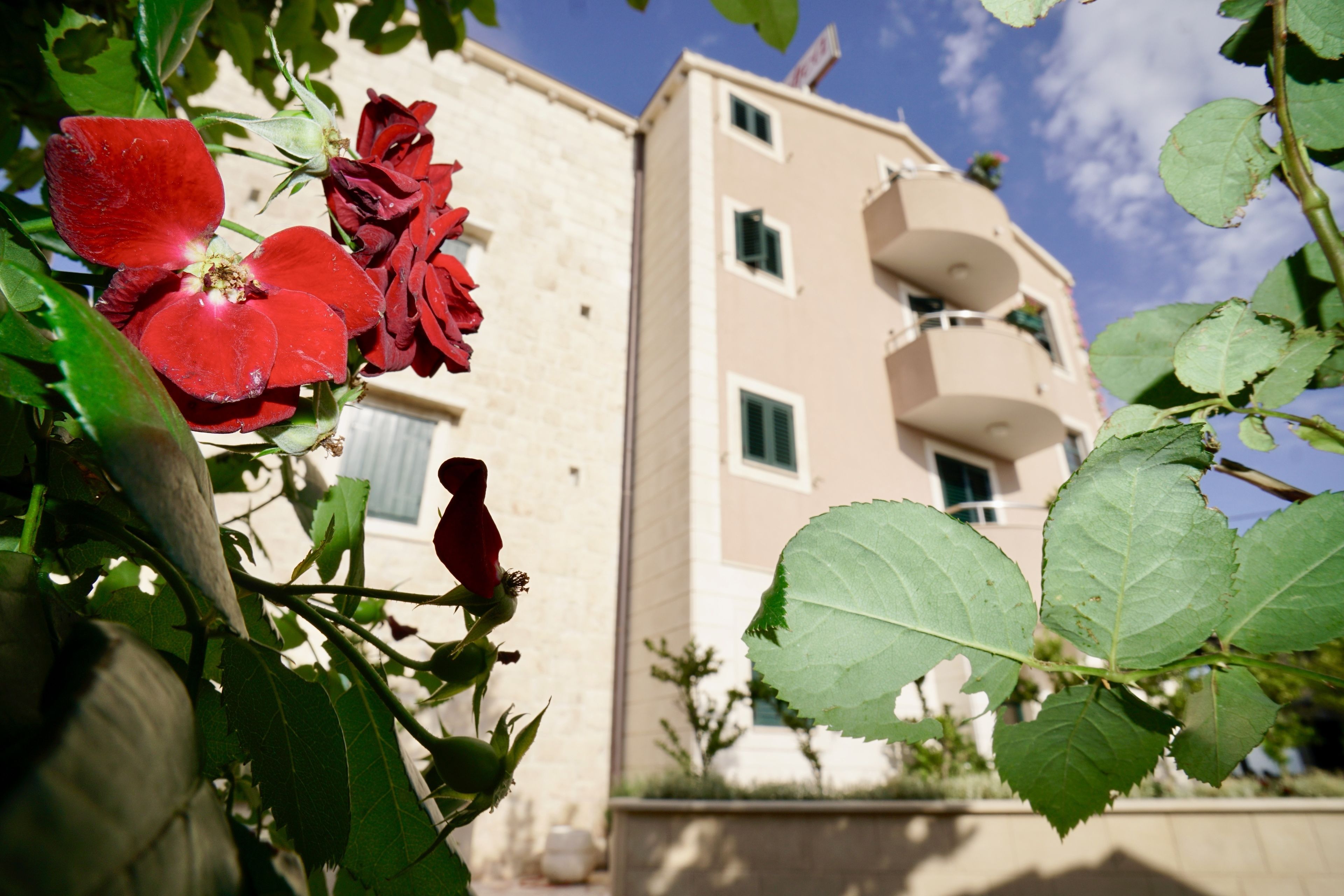 Ein Gebäude mit einer beige farbenen Fassade und mehreren Balkonen unter einem klaren Himmel.
