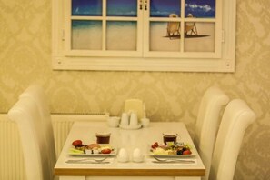 A dining table with plates of food, cups, and cutlery. - Hotel Sahiner (Nigde)