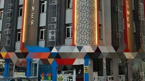 Un edificio de hotel de varios pisos con pancartas verticales que muestran el nombre 'HOTEL SAHINER'.