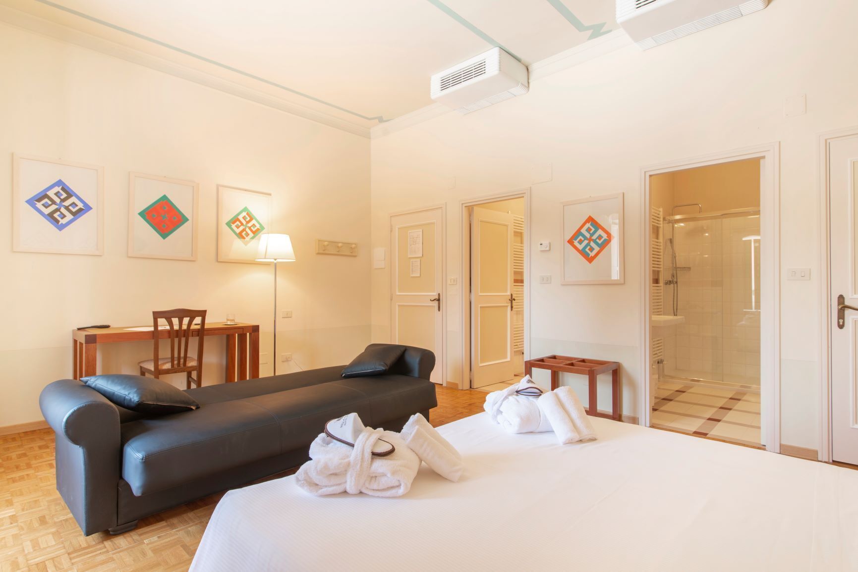 Une chambre d’hôtel comprenant un lit, un canapé, un bureau et un espace douche.