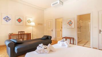 Une chambre d’hôtel comprenant un lit, un canapé, un bureau et un espace douche.
