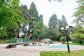 A park with a bridge, a pool, and a lamp post. - Villa Quiete (Montecassiano)