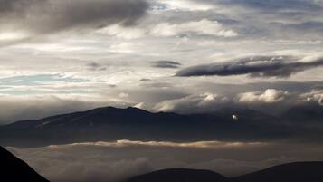 Un paysage de montagne avec des nuages et un ciel dégagé.