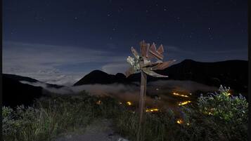 Cielo estrellado con un cartel de metal en una zona montañosa.
