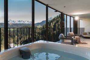 A modern interior with a large window overlooking a mountainous landscape. - Ganis Resort (Nova Ponente)