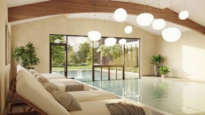 A modern indoor pool area with a sofa, wooden beams, and hanging lights. - Ganis Resort (Nova Ponente)