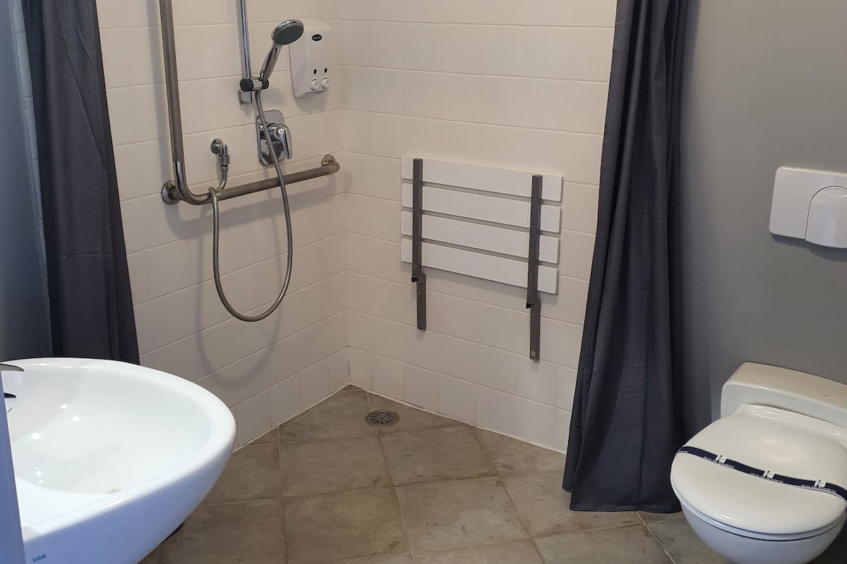 A bathroom with a shower, toilet, and sink.