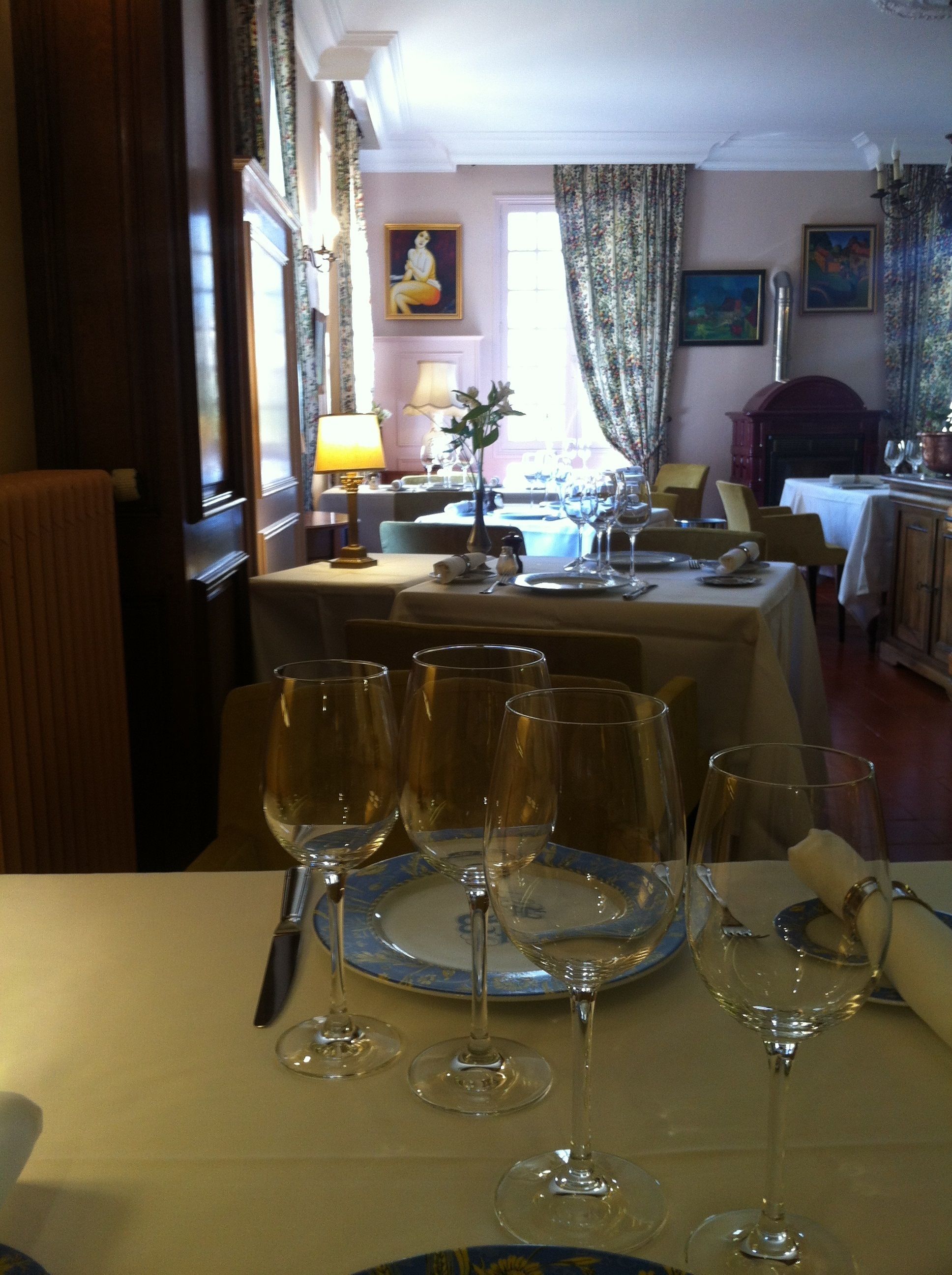 Un coin repas avec une table mise pour le repas, comprenant des verres à vin et des assiettes.