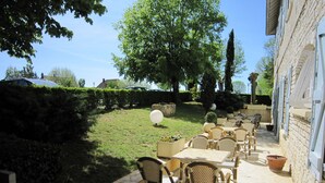 An outdoor patio with wicker furniture and potted plants. - Hostellerie de la Bouriane (Gourdon)