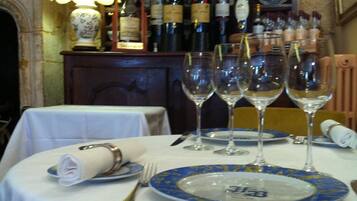 Mesa servida para comer con copas de vino, platos y cubiertos.
