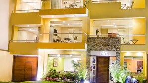 A multi-story hotel with balconies, a stone facade, and a well-lit entrance. - Alwa Premium Hotel Boutique (Arequipa)