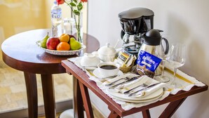 A breakfast setup with a fruit bowl, coffee maker, and wine glasses on a table. - Alwa Premium Hotel Boutique (Arequipa)