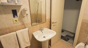 A bathroom with a sink, a mirror, a towel, and a shower. - Hostal Las Gaviotas (Nijar)