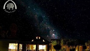 A house with a large open porch and a view of the night sky. - Elephant's Nest Guest House (Graskop)
