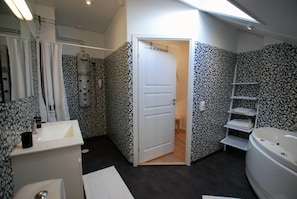 Un baño moderno con ducha, bañera y lavamanos blanco.
