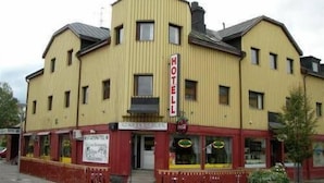 A yellow building with a sign reading "HOTEL" on the front. - Avesta Stadshotell (Avesta)
