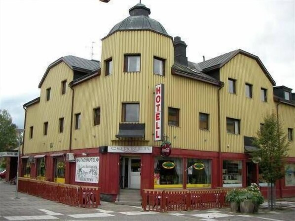 A yellow building with a sign reading "HOTEL" on the front.
