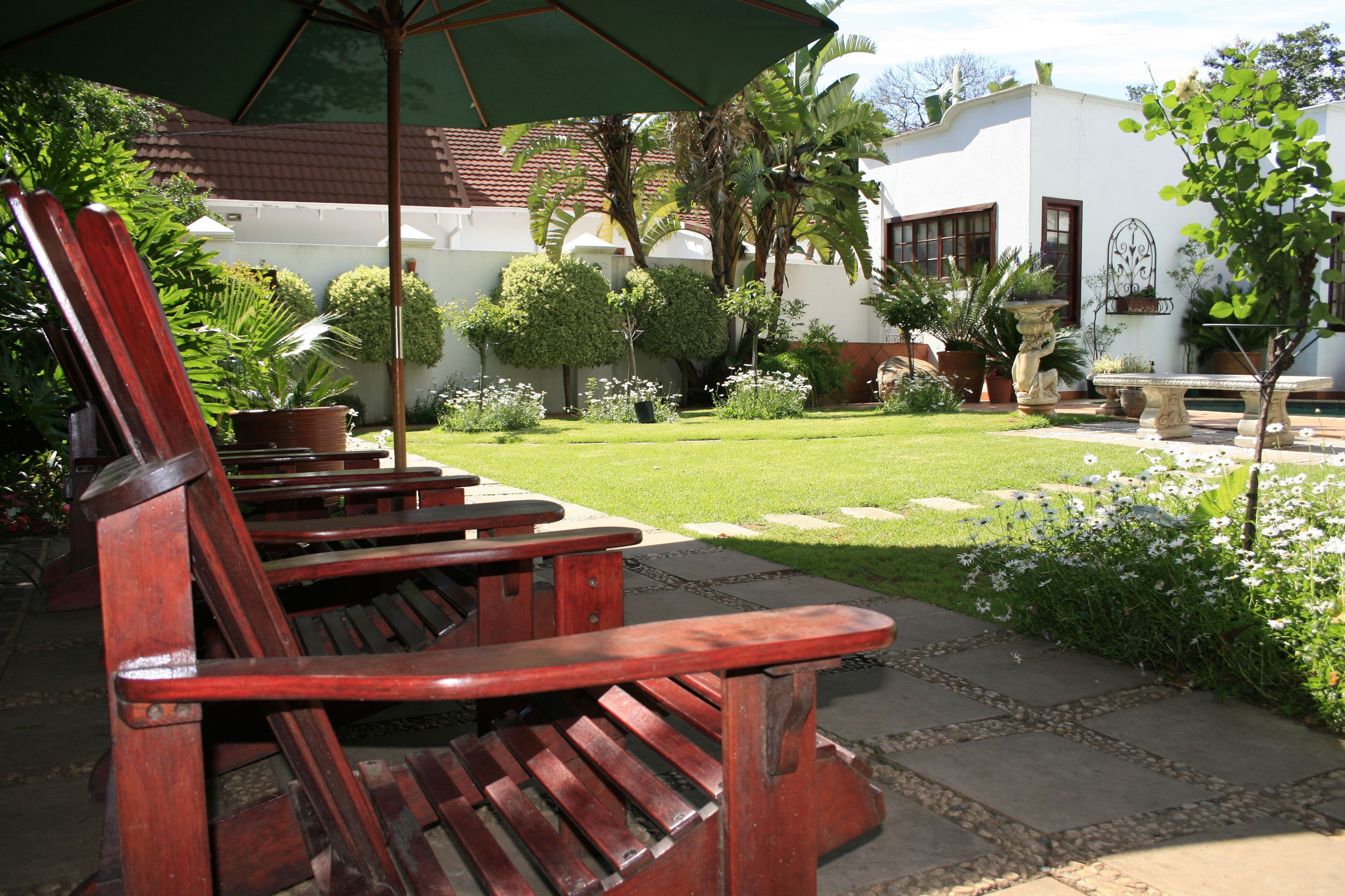 A patio area with wooden benches and a stone pathway.