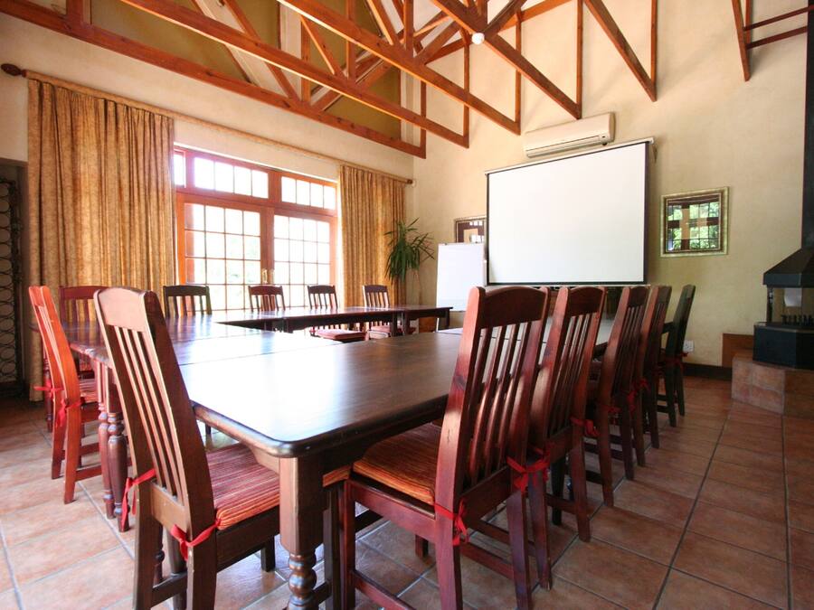 Un salón de conferencias con una larga mesa y sillas, una pizarra y una chimenea.