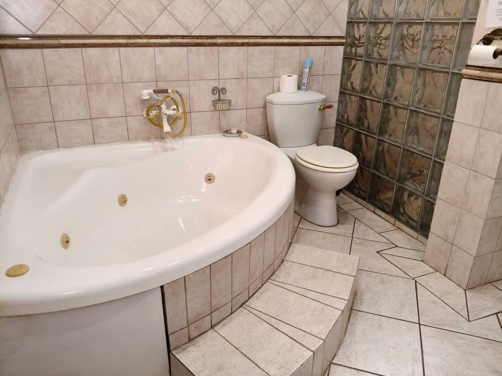 Un baño con una bañera independiente, inodoro y zona de ducha.