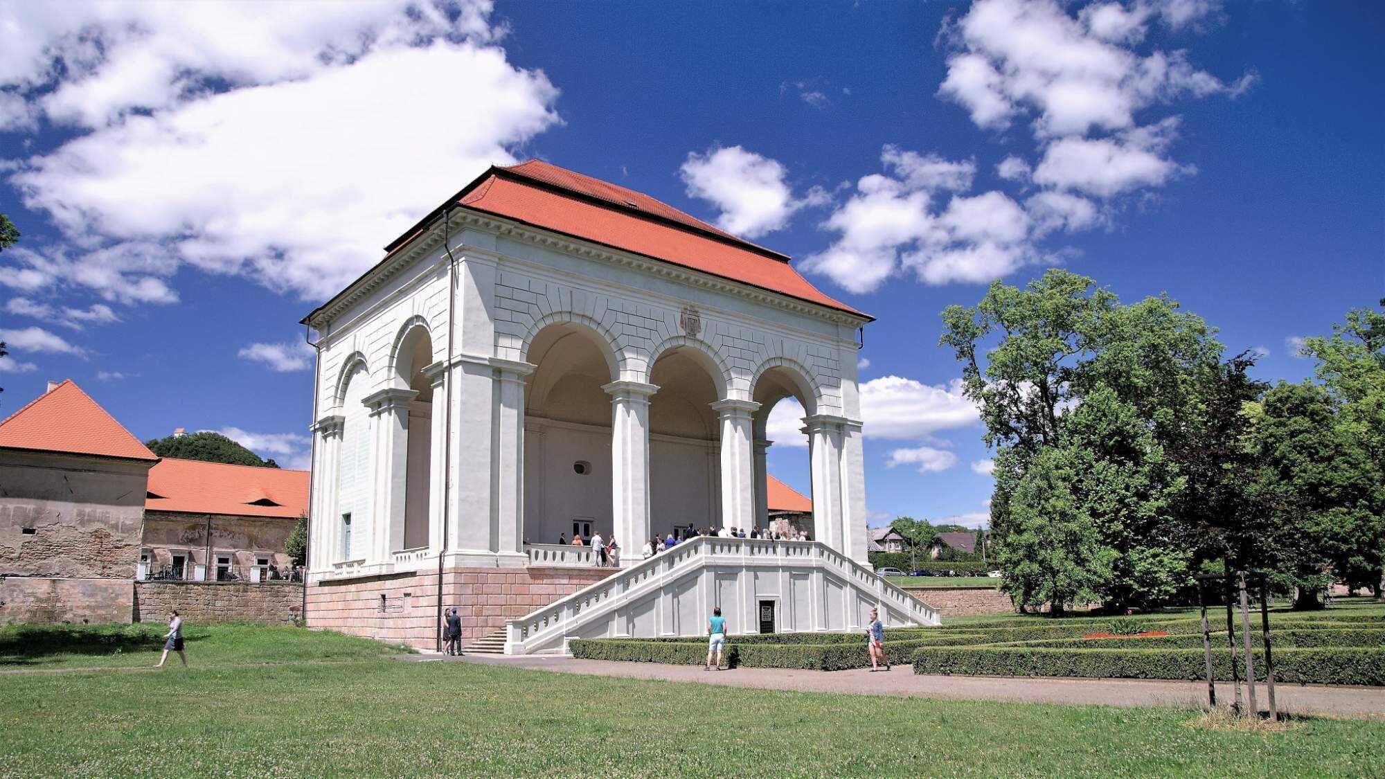 Ein weißes Gebäude mit rotem Dach und einer Treppe, die hinauf führt.