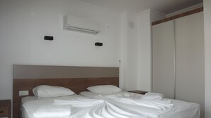 Una cama bien hecha con sábanas blancas en una habitación de hotel.